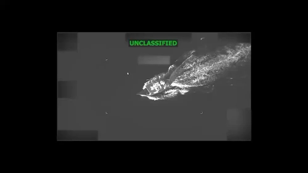 Official aerial video frame showing a vessel and its wake before the strike